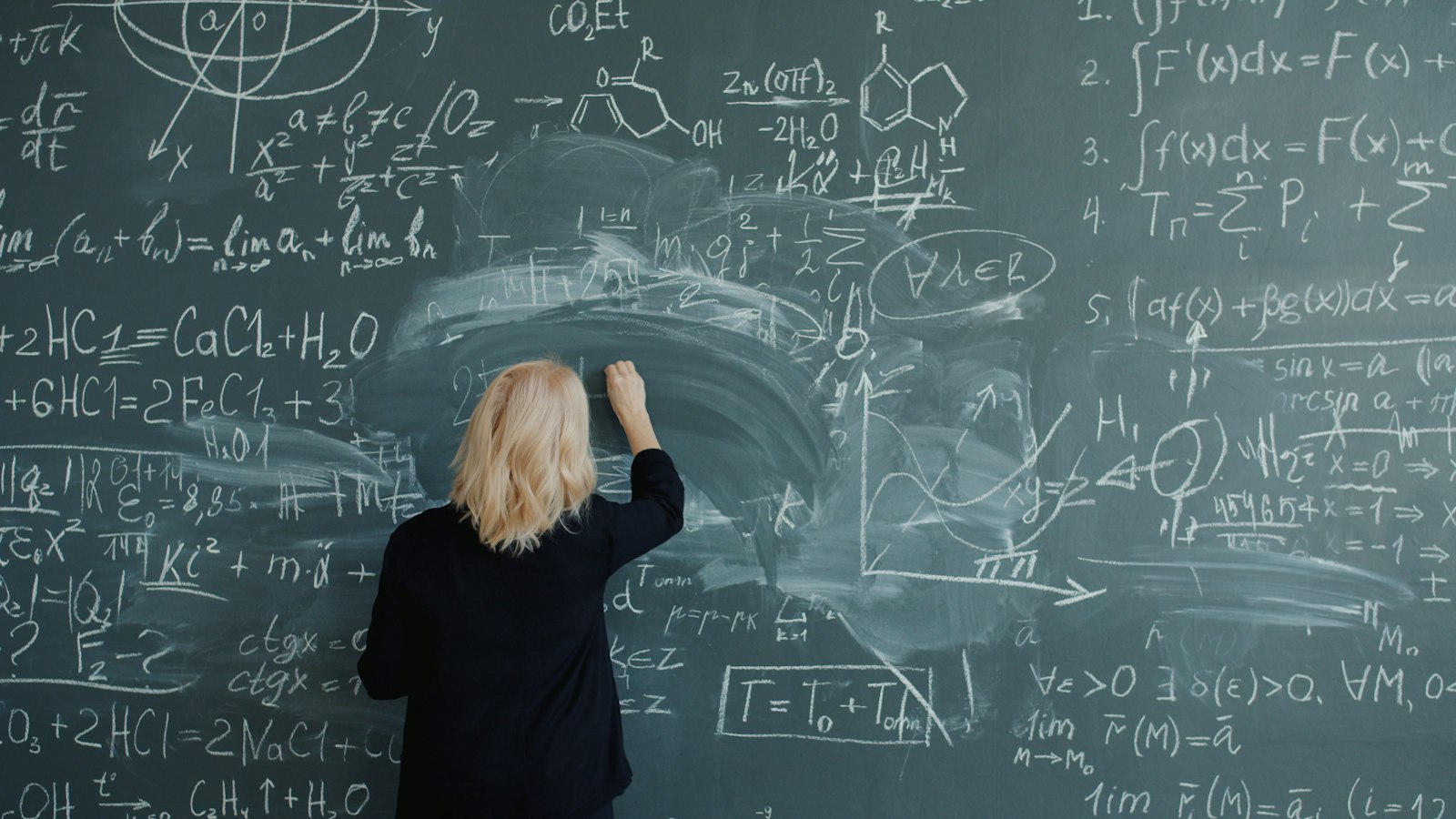 Tahtaya matematik formülleri yazan öğretmen
